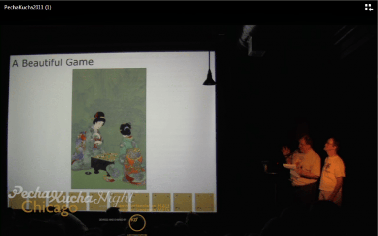 Mark Rubenstein (left) and Bob Barber (right) present “A Beautiful Game” at PechaKucha Night Chicago in 2011. Photo courtesy of Mark Rubenstein. Source: https://aga-news-archive-viewer.azurewebsites.net/api/news-archive/article/2642. The presentation can be viewed here: https://www.youtube.com/watch?v=mffjg1pRtaE.